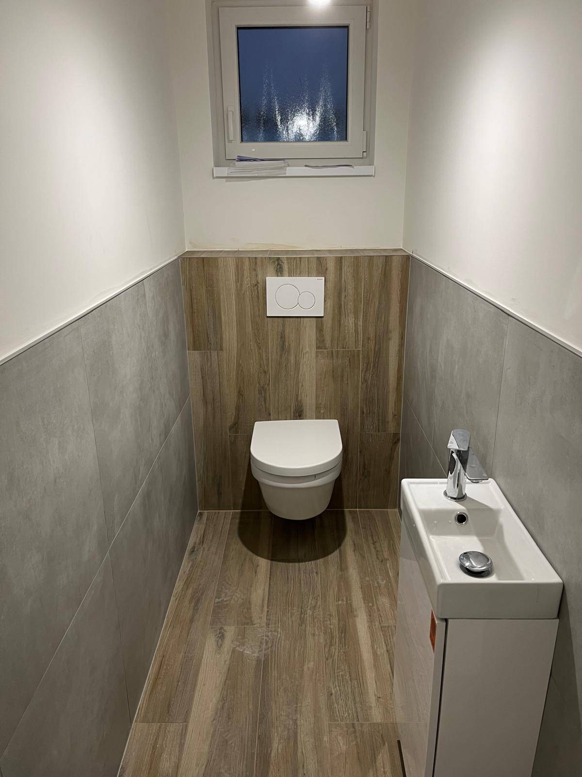 WC s obkladom v drevodekore a sivými obkladačkami